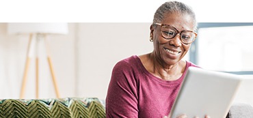 Woman using an iPad sitting in her living room