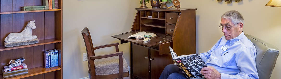 Resident in a chair while reading a book