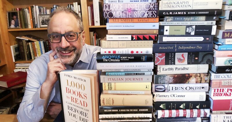 james mustichevent posing next to books